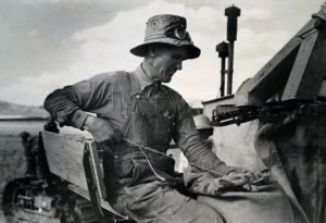 Image of Mormon farmer who lives in Snowville, Utah and who farms in Oneida County, Idaho, bagging wheat